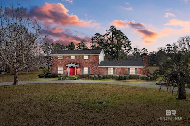 colonial inspired home featuring a yard