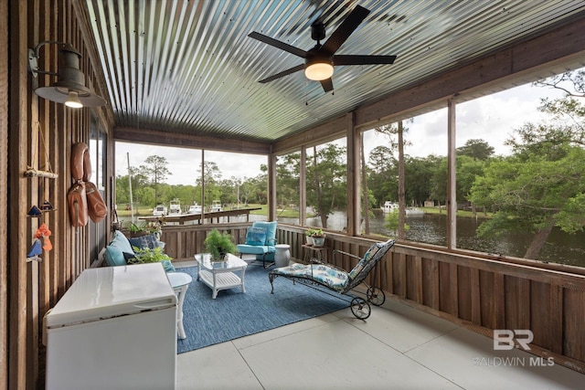 sunroom with a water view and ceiling fan