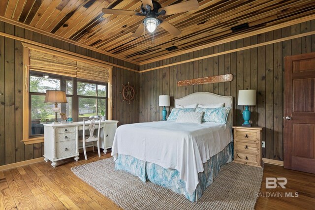 bedroom with wood walls and wood finished floors