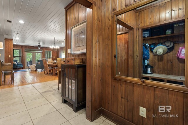 interior space with wooden walls, tile patterned flooring, and visible vents