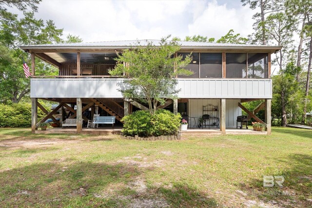 back of house with a yard, a patio, a sunroom, and stairs