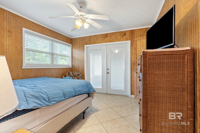 bedroom with french doors, ceiling fan, wood walls, and light tile patterned floors