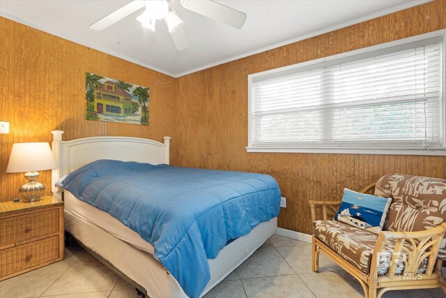 bedroom featuring crown molding, tile patterned flooring, a ceiling fan, and wood walls