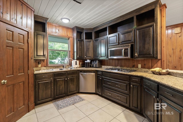 kitchen featuring open shelves, stainless steel appliances, wood walls, and light tile patterned flooring