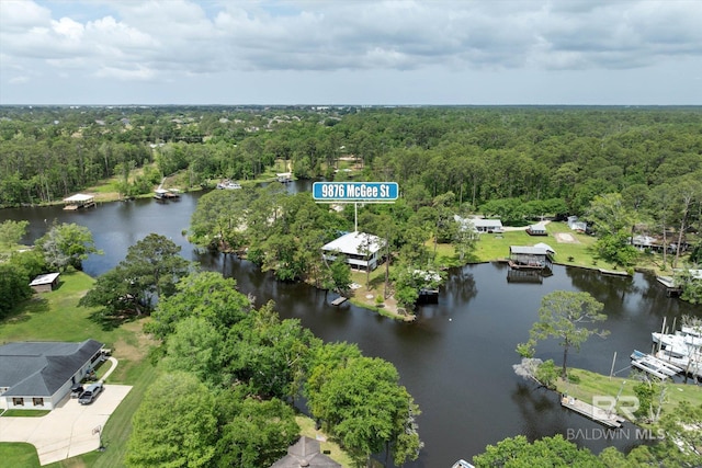 aerial view with a water view and a wooded view