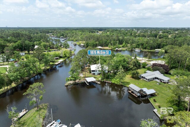 birds eye view of property with a water view and a wooded view