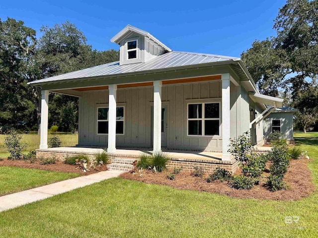 modern farmhouse featuring a front lawn and covered porch