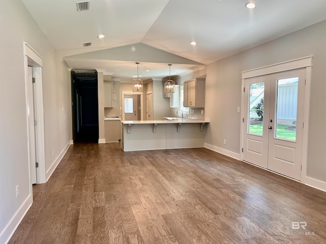 unfurnished living room featuring vaulted ceiling, dark hardwood / wood-style floors, french doors, and sink