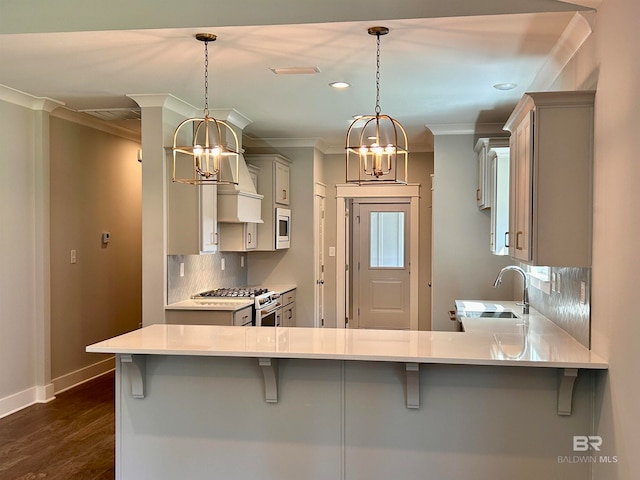 kitchen featuring sink, kitchen peninsula, hanging light fixtures, and a breakfast bar area