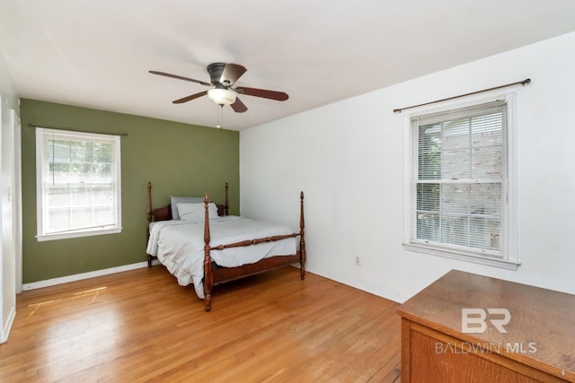 bedroom featuring light hardwood / wood-style flooring, multiple windows, and ceiling fan