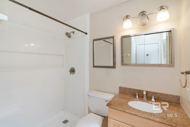 bathroom with walk in shower, vanity, and toilet