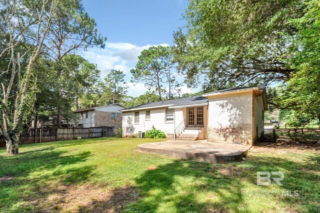 rear view of property with a lawn and a patio area