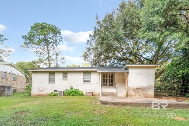 rear view of property featuring cooling unit, a yard, and a patio area