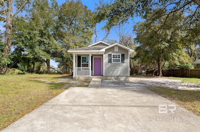 view of outbuilding with covered porch and fence