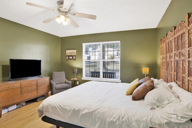 bedroom featuring wood-type flooring, ceiling fan, and a textured ceiling