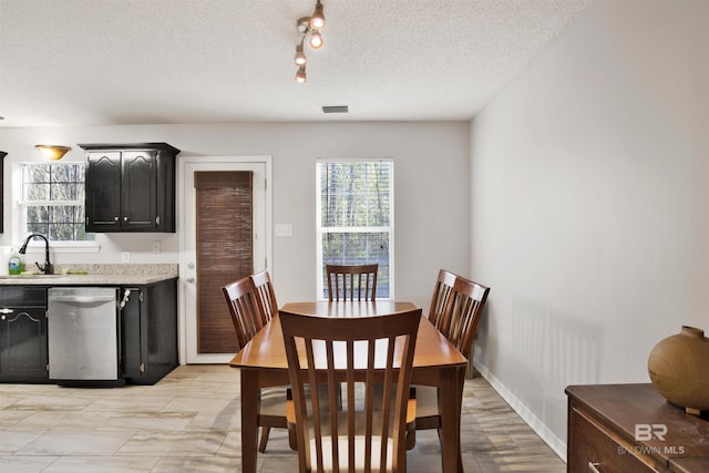 dining room featuring sink and a textured ceiling