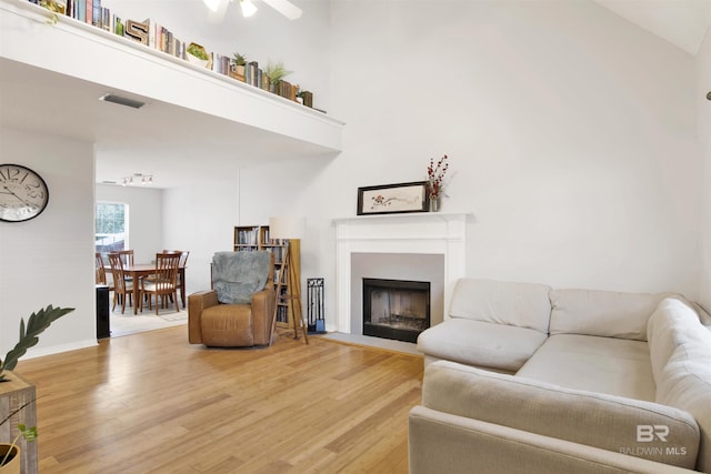 living room with wood-type flooring and a high ceiling