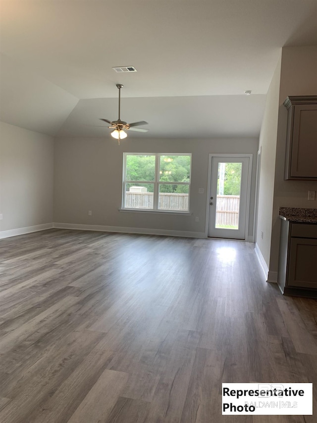 unfurnished living room featuring hardwood / wood-style flooring, ceiling fan, and vaulted ceiling