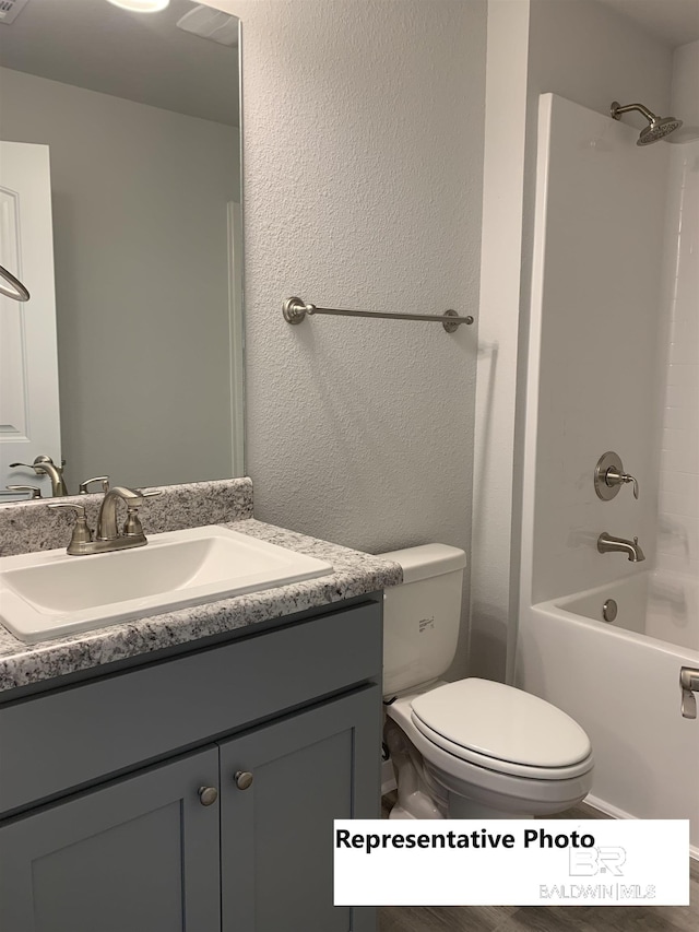 full bathroom with toilet, vanity, and washtub / shower combination