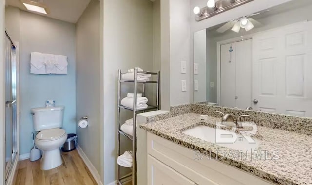 572 E Beach Blvd Unit 318, Gulf Shores, AL 36542 - bathroom with vanity, toilet, wood finished floors, a shower stall, and ceiling fan