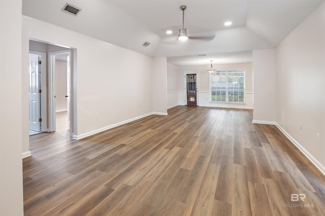 unfurnished living room with vaulted ceiling, wood-type flooring, and ceiling fan with notable chandelier