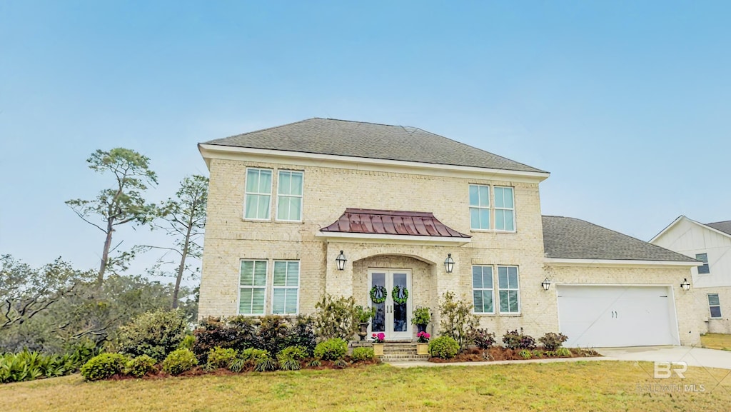 view of front of house with a front lawn, roof with shingles, french doors, driveway, and an attached garage