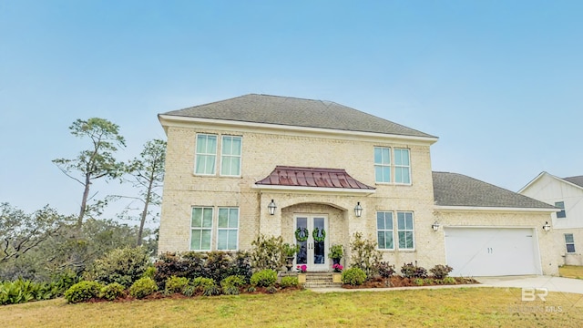 view of front of property with a shingled roof, concrete driveway, a front lawn, french doors, and a garage