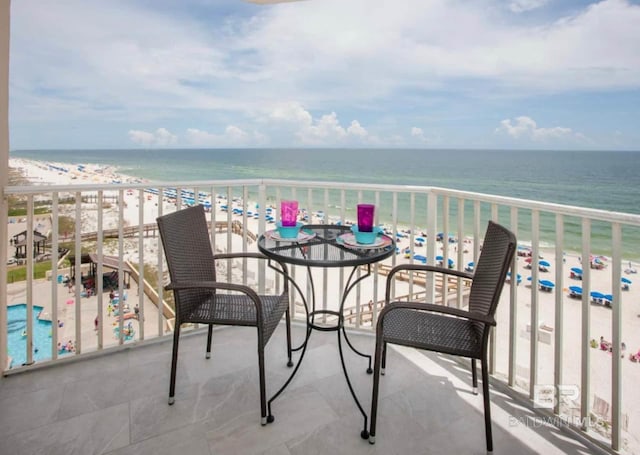 balcony with a water view and a view of the beach