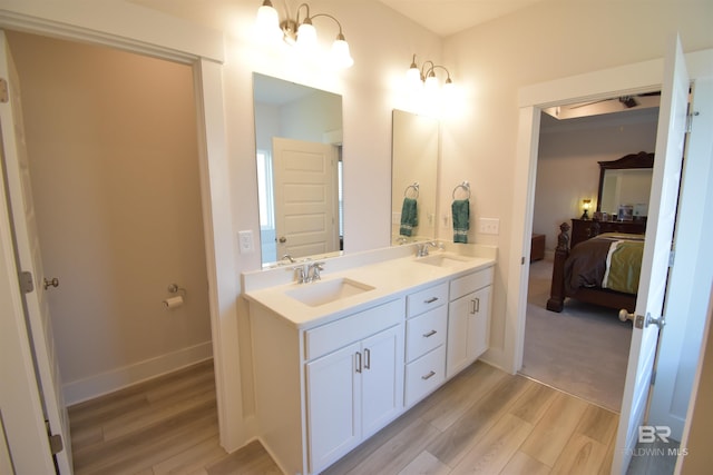 1123 Pheasant Cir, Foley, AL 36535 - ensuite bathroom with connected bathroom, double vanity, a sink, and wood finished floors