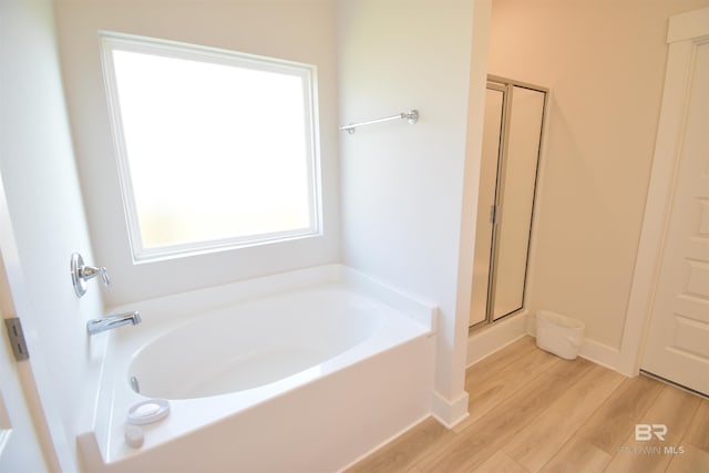 1123 Pheasant Cir, Foley, AL 36535 - bathroom featuring wood finished floors, a bath, and a stall shower