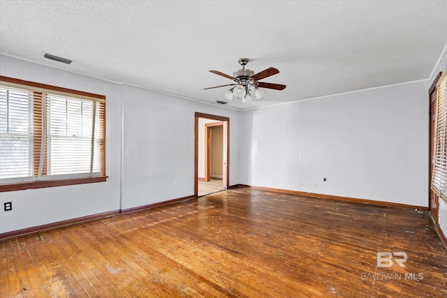 empty room featuring a textured ceiling, ceiling fan, and dark wood-type flooring