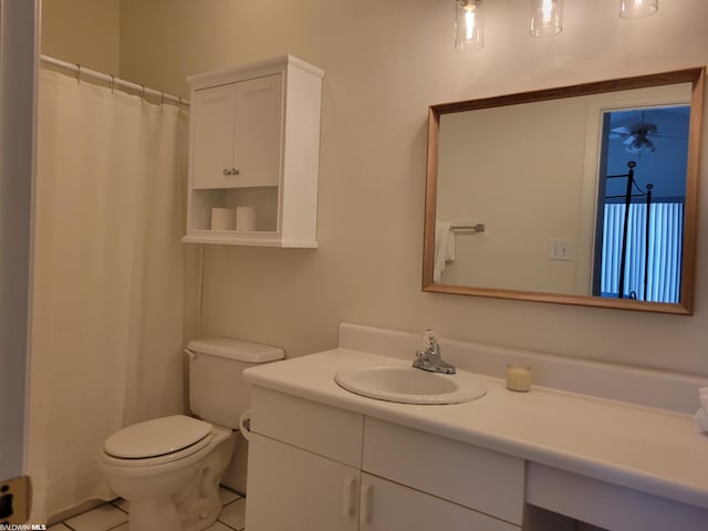 bathroom featuring toilet, vanity, and tile flooring