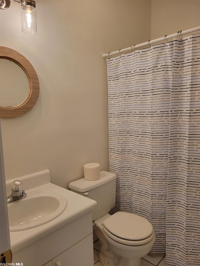 bathroom featuring toilet, tile flooring, and vanity