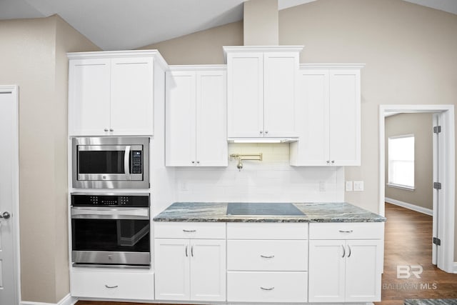 10210 Lyttleton Loop, Lillian, AL 36549 - kitchen with vaulted ceiling, stainless steel appliances, white cabinetry, and dark stone countertops