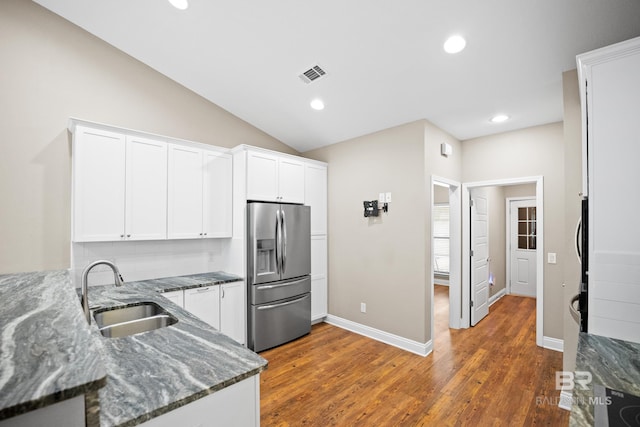 10210 Lyttleton Loop, Lillian, AL 36549 - kitchen with dark stone countertops, a sink, stainless steel refrigerator with ice dispenser, white cabinets, and visible vents