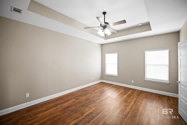 10210 Lyttleton Loop, Lillian, AL 36549 - spare room featuring a raised ceiling, baseboards, dark wood-type flooring, and a ceiling fan