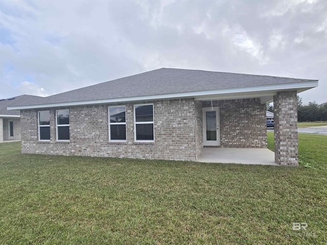 14530 Dayton Cir, Foley, AL 36535 - rear view of house featuring brick siding, a patio, a yard, and roof with shingles