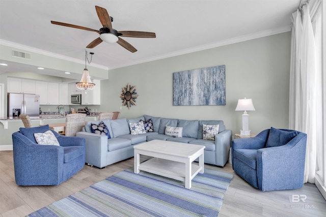 living room with a ceiling fan, crown molding, light wood-style floors, and visible vents