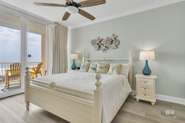 bedroom featuring a ceiling fan, wood finished floors, baseboards, crown molding, and access to outside