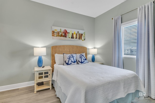 bedroom featuring baseboards and wood finished floors