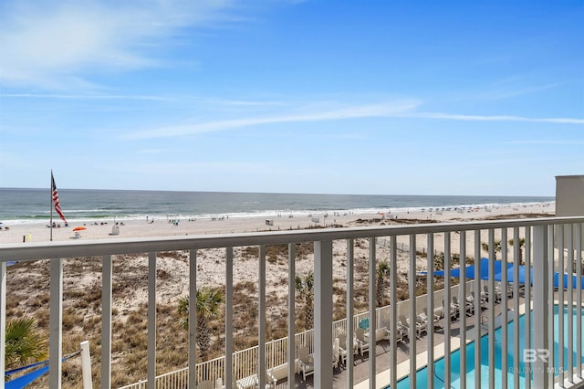 balcony featuring a view of the beach and a water view