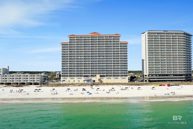 drone / aerial view with a city view, a view of the beach, and a water view