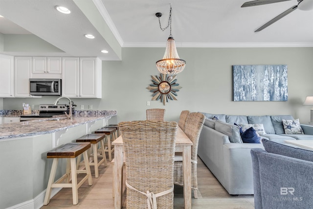 interior space featuring baseboards, light wood-type flooring, ornamental molding, recessed lighting, and a ceiling fan