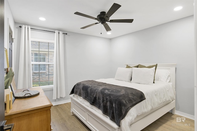 bedroom featuring light wood-style flooring, multiple windows, baseboards, and recessed lighting