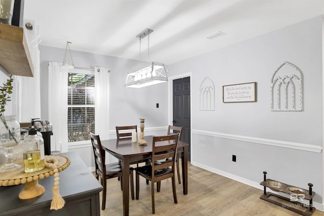 dining room featuring light wood-style flooring and baseboards