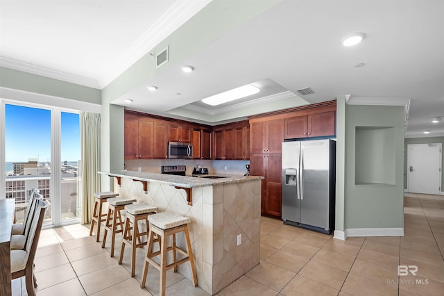 kitchen featuring stainless steel appliances, a peninsula, light tile patterned flooring, and crown molding