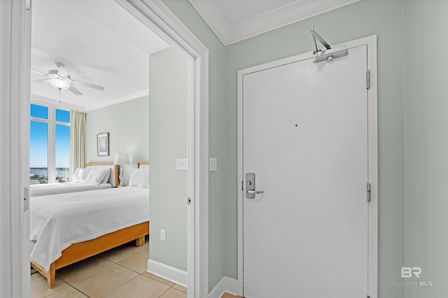 bedroom featuring crown molding, light tile patterned floors, baseboards, and ceiling fan