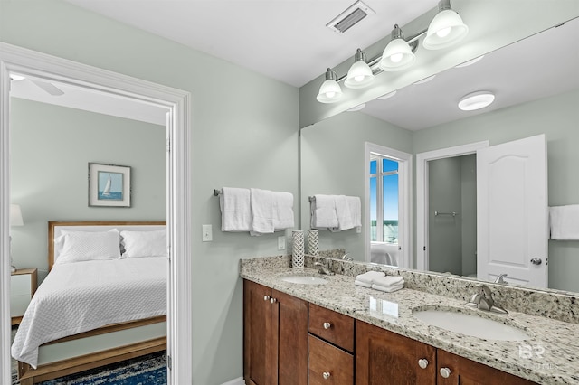 bathroom with double vanity, visible vents, ensuite bath, and a sink