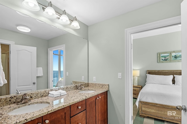 bathroom with a sink, double vanity, and ensuite bathroom