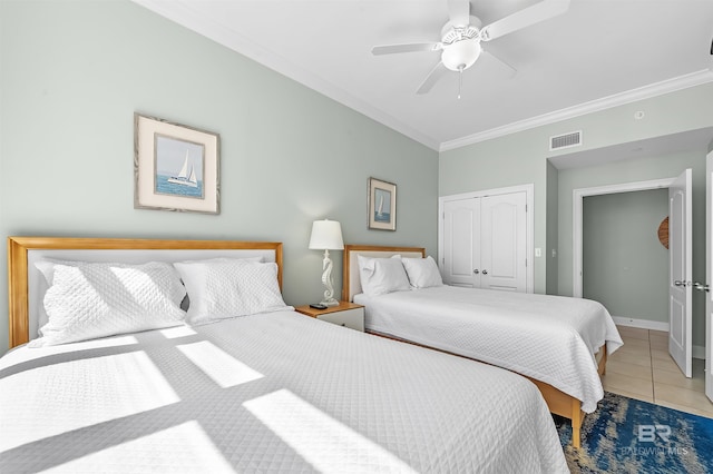 bedroom featuring visible vents, crown molding, baseboards, light tile patterned floors, and a closet